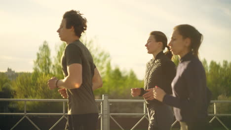 Eine-Gruppe-Professioneller-Läufer-Läuft-Am-Sonnigen-Morgen-In-Der-Stadt-Und-Joggt,-Um-Sich-Fit-Zu-Halten